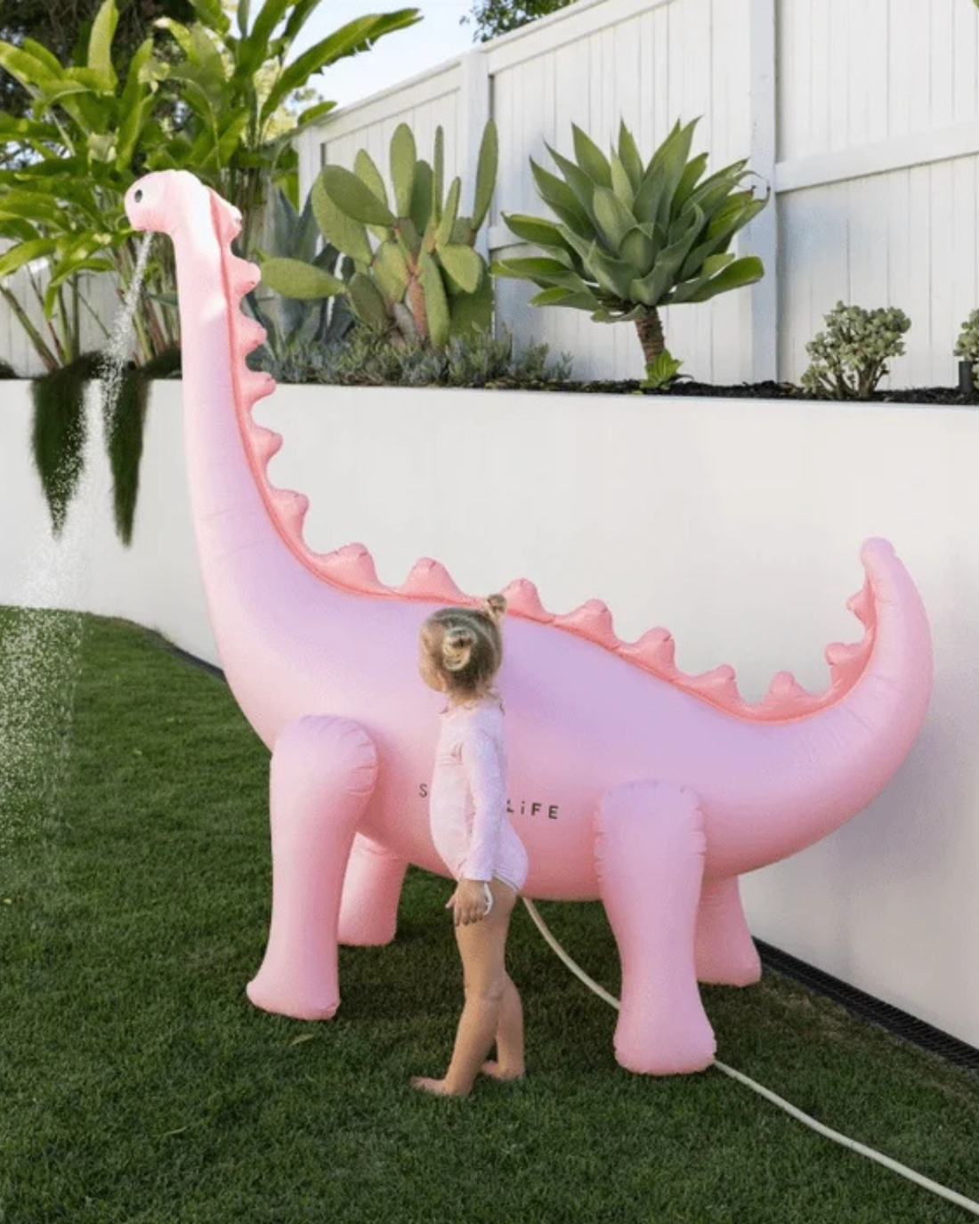 The Inflatable Giant Dino Sprinkler by SUNNYLiFE in Pink
