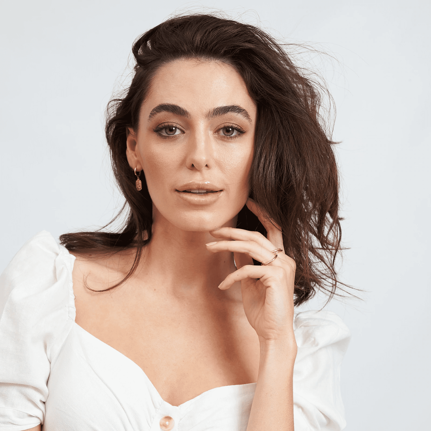 arms of eve mendoza gold huggie earrings on model with brown hair