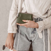 lady holding status anxiety volatile wallet purse in khaki green