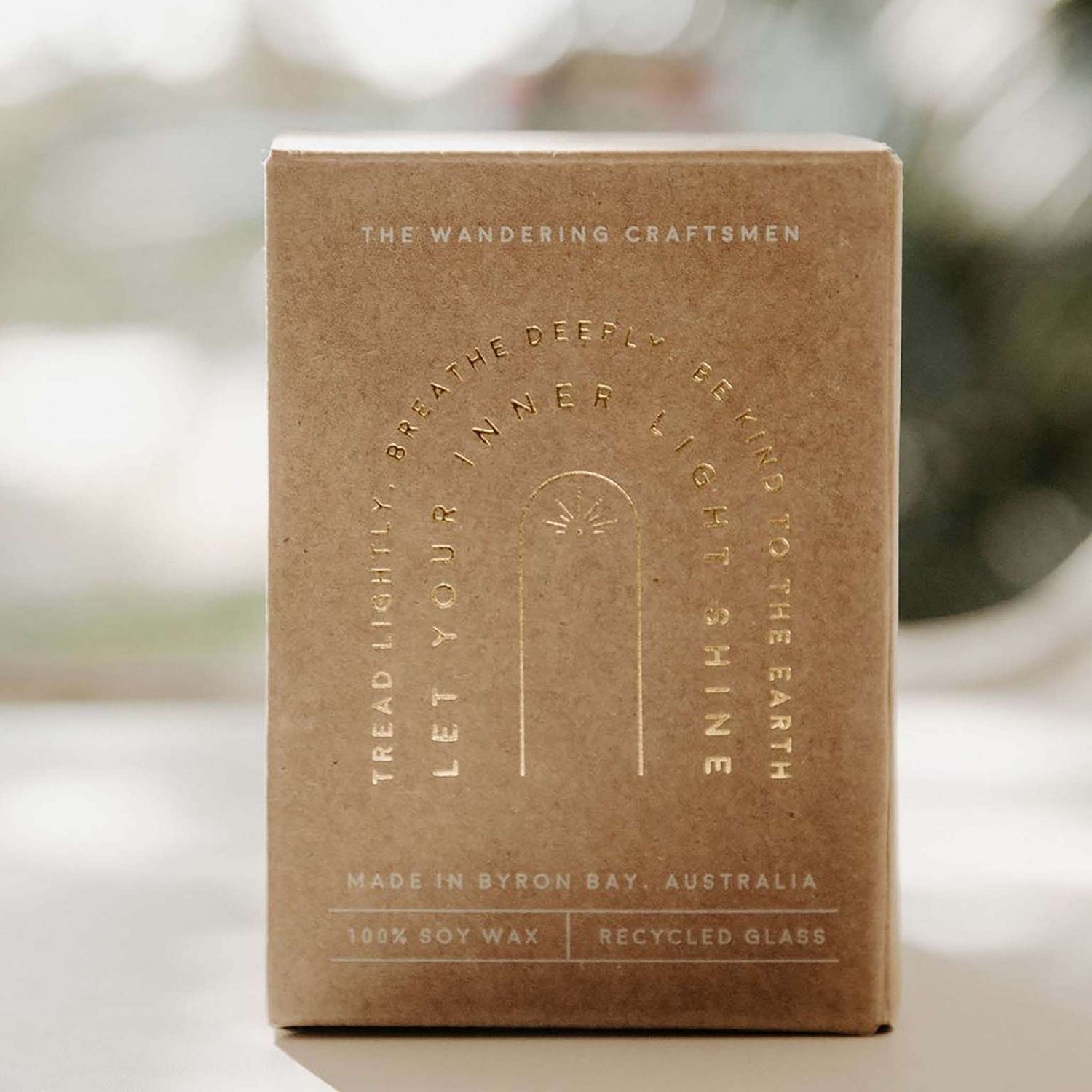 The wandering craftsmen candle in kraft gift box with gold writing.